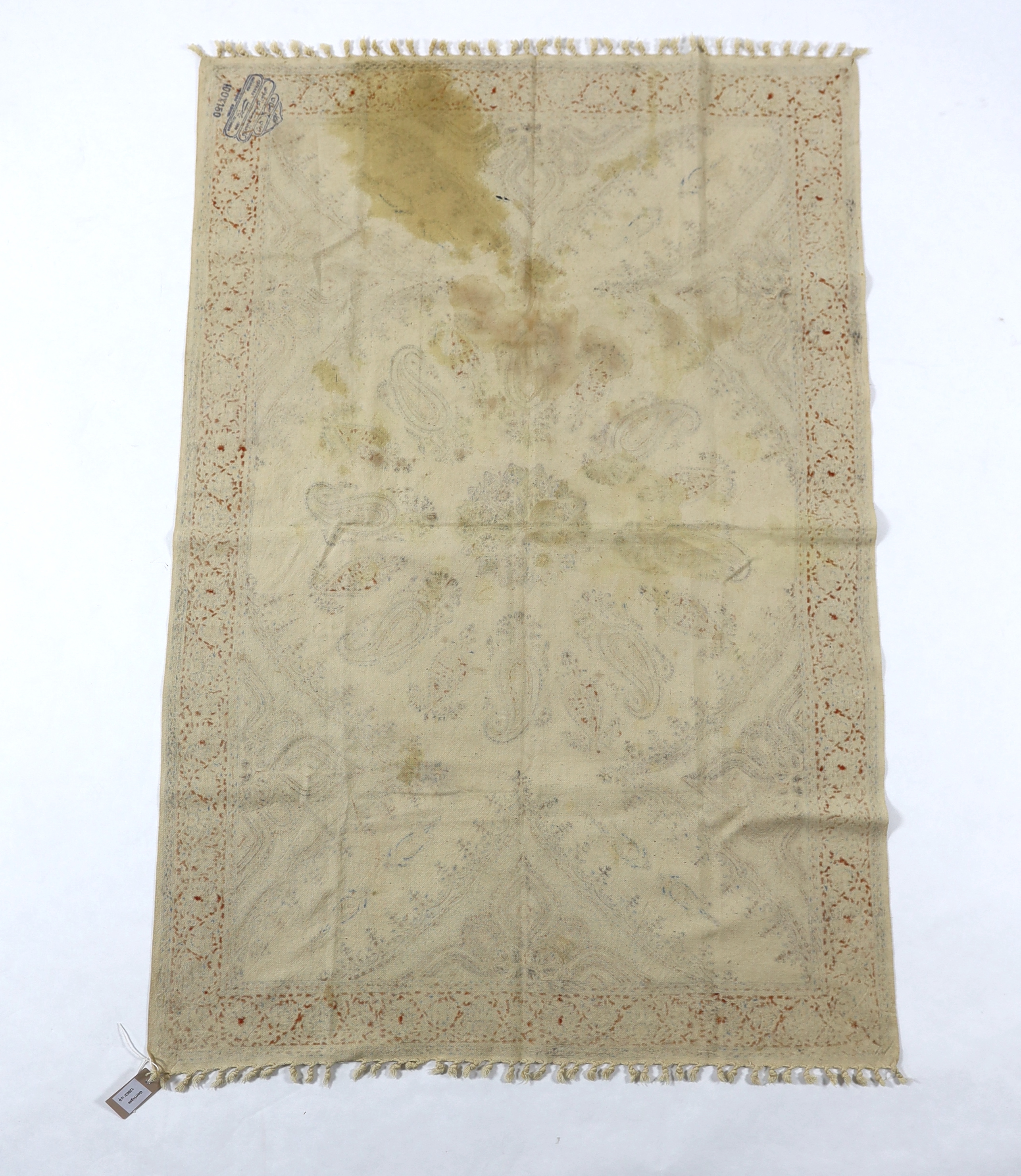 A 20th century Iranian printed paisley shawl, designed using indigo, red and ochre dyes, finished with knotted tassels either end, with an ink maker’s stamp on reverse, 148cm long x 100cm wide